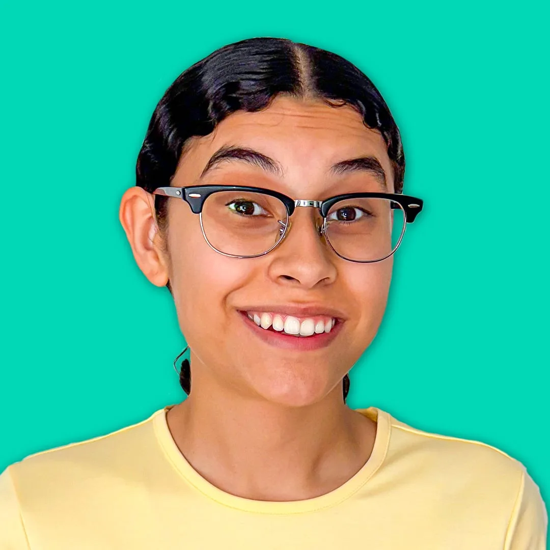 Jenny Hoyos smiling in glasses against a teal background